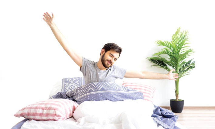 Man stretching in bed